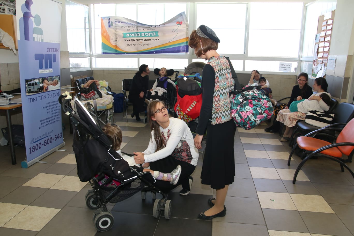 yachad indoor pic at activity volonteers with kids and mother