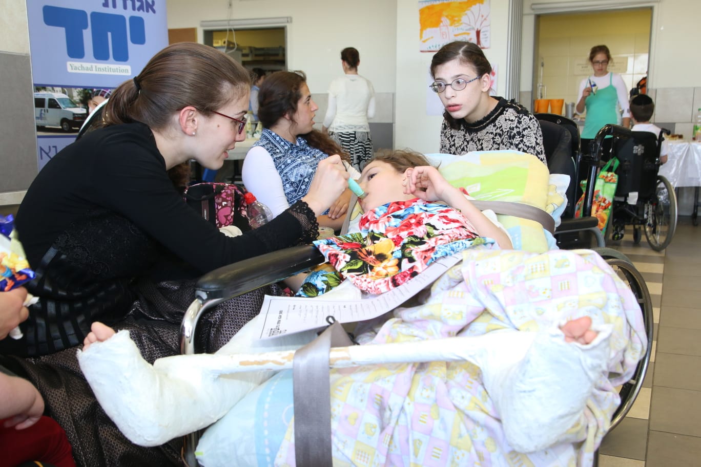 yachad pic of volonteer feeding severly disabled child with syringe